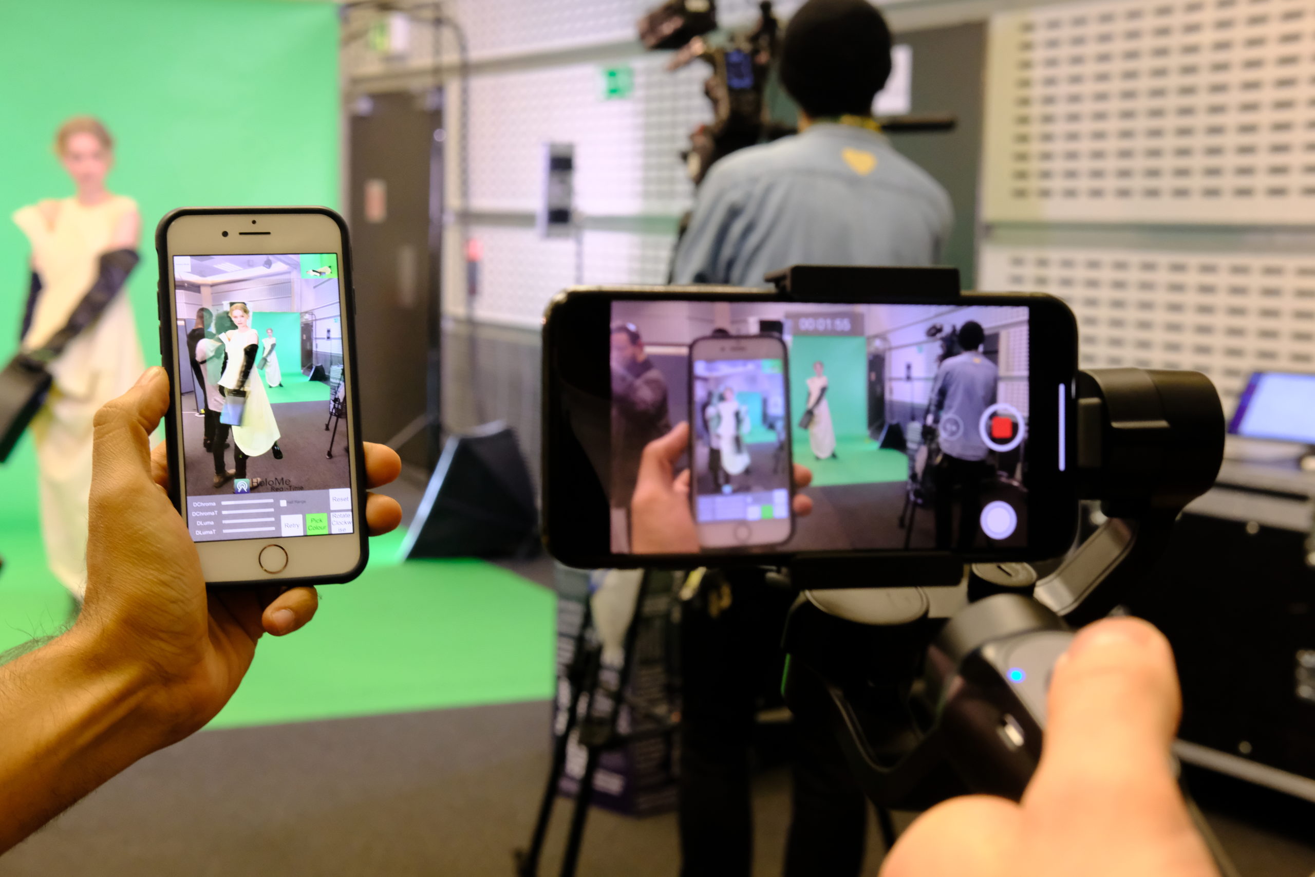 Image of phones taking pictures and video of a model on a green screen, Fashion Innovation Agency